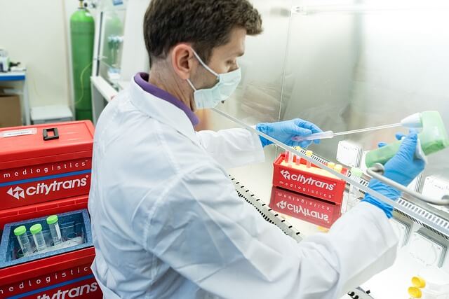 A scientific researcher pipetting liquid into a test tube in a laboratory